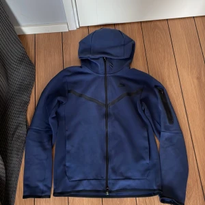 Mörk blå Nike tech fleece  - Säljer en mörk blå Nike tech fleece som är en äldre model som inte säljs längre och inte i denna färg heller. Den är i bra skicka då den är använd ett par gånger utan några defekter annars har den bara funnits i min garderob. 