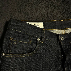  J.Lindeberg jeans mörkblåa - Snygga mörkblå jeans från J.Lindeberg med klassisk design och kontrasterande sömmar. .