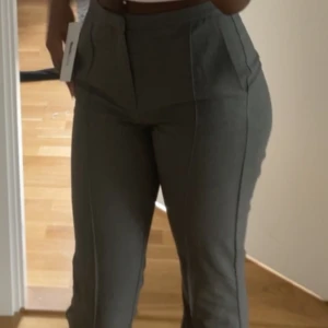 Grå kostymbyxor - Snygga grå kostymbyxor med hög midja och en stilren design. Byxorna är från Gina och köpte de för 400kr. 