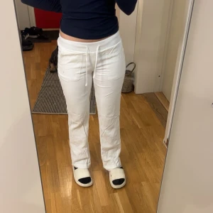 Vita linnebyxor med låg midja - Snygga vita linnebyxor med låg midja och avslappnad passform. Byxorna har en dragsko i midjan för justerbar passform. Perfekta för en stilren och bekväm look. De har ett extra tyg på insidan så dem är tjockare än vanliga linnebyxor 