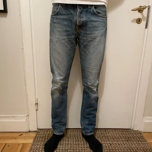 Nudie jeans - Tja, säljer ett par feta Nudie Steady EddieJeans. Jeansen är i storlek W30 L32 och är sitter riktigt bra. De är i mycket bra skick bortsett från skadan i bild 5, som inte syns vid användning. Nu säljer jag dessa för endast 199 kr, samt fri frakt. Hör av er vid frågor och bud.
