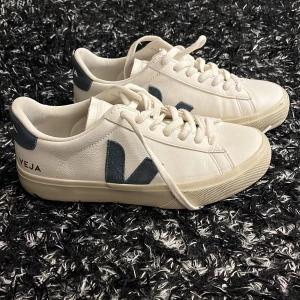 Vita sneakers från Veja - Snygga vita sneakers från Veja med blå detaljer och snörning. Perfekta för en stilren look. Tillverkade i skinn. Köpta på NK för 1800, dem är i storlek 38 och andvända två gånger ❤️ pris går att diskutera 