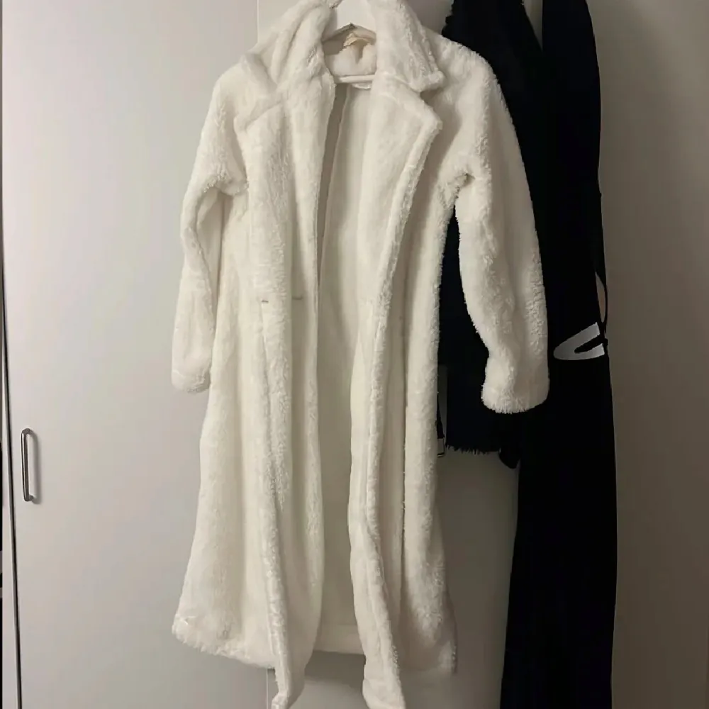 Säljer en supermysig vit teddyjacka som är perfekt för kyliga dagar. Jackan har en lång och fluffig design med långa ärmar och en klassisk krage. Den är både stilren och bekväm, vilket gör den till ett måste i garderoben. Perfekt för att hålla sig varm och snygg under vintern.. Takit.