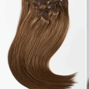 Brun hårförlängning med clips - Snygg brun hårförlängning med clips från rapunzel of sweden. Det är äkta hår som går att platt, locka och tvätta. Aldrig använd.  Perfekt för att snabbt få längre och fylligare hår. Clipsen är diskreta och lätta att använda. 40cm långa. nypris: 1500kr