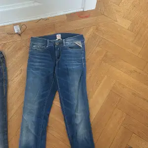 Snygga blå jeans från Replay med en klassisk femficksdesign och knappgylf. Jeansen har en lätt tvättad look med ljusare partier och är perfekta för en avslappnad stil.