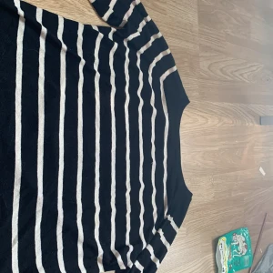 Randig tröja från Zara - Säljer en snygg randig tröja från Zara i svart och beige. Tröjan har långa ärmar och en klassisk passform som passar perfekt till vardags. Den är tillverkad i ett mjukt material som känns skönt mot huden.