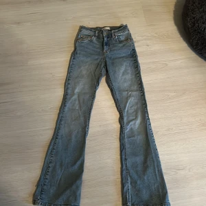 Blå bootcut jeans från Gina tricot  - Snygga blå bootcut jeans från Gina tricot med klassisk femficksdesign. De har en dragkedja och knapp framtill. Perfekta för en shopping Eller bara va hemma jeans. Passar bra till sneakers eller alla andra skor. Dom har ett litet hål vid sidan på benet där nere men de syns knappt . Priset är inte satt öppen för alla förslag på pris.
