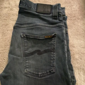 Nudie jeans - Snygga mörkgrå jeans från Nudie Jeans med en klassisk femficksdesign! Bara att skriva vid intresse!