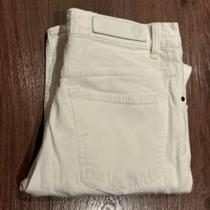 Vita jeans från tiger of Sweden - Snygga vita jeansbyxor med klassisk femficksdesign och knappgylf. Perfekta för en stilren look. Passar bra till både vardag och mer uppklädda tillfällen. Storlek W34 L34. Jeansen är i mycket bra skick ✅