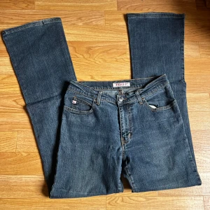 Blå bootcut jeans från Miss Sixty - Snygga blå jeans från Miss Sixty med klassisk bootcut-modell. Jeansen har normal midja, raka ben som blir vidare nertill. Lite nötta på ena kanten. (Se Bild) 🩷