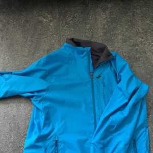 Blå vindjacka Peak Performance  - Hej, säljer denna feta flis/windbreaker från peak, köpt för länge sedan. Den har inga defekter mm men en nackdel skulle nog vara att det är windbreaker utan luva men det borde inte vara några konstigheter. Priset kan diskuteras!