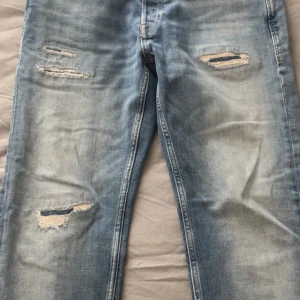 J&J Jeans strl 30/32 (tapered Mike) - Säljer ett par feta jeans som är perfekta till sommaren. Jeansen har slitningar och är i storlek 30W 32L (slim fit) Modellen är tapered Mike. Köpta från Jack and Jones butik i Sthlm. Pris kan diskuteras. Hör av er om ni har frågor.