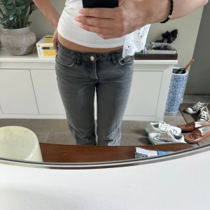 Gråa jeans med låg midja - Säljer ett par gråa jeans med låg midja och klassisk femficksdesign. Jeansen har en rak passform och är tillverkade i mjukt denimtyg. Perfekta för en avslappnad och stilren look.