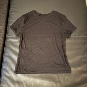 Svart t-shirt från H&M Divided - En basic svart t-shirt från H&M Divided i storlek S. Klassisk rund halsringning och korta ärmar. Tillverkad i mjuk bomull, perfekt för en enkel och clean look. Passar till allt och är ett måste i garderoben. Är genomskinlig!