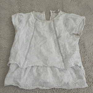 Vit blus från Zara  - Superfin vit blus från Zara. Blusen har korta ärmar med söt kant och dubbla lager nertill. 