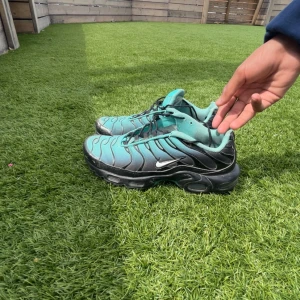 Nike Air Max Plus Tn blå/svarta sneakers - Nike Air Max Plus Tn sneakers i blått och svart med ikoniska vågformade detaljer och svart sula. Skorna har mesh-överdel, snörning och Tn-logga.Buda på dem här skorna de är i storlek 42,5