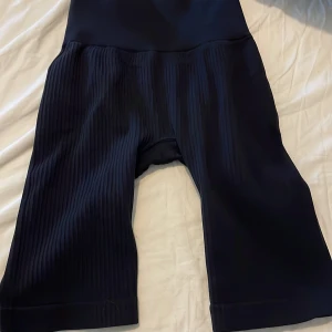 Svarta ribbade leggings från SOC - Svarta leggings från SOC med ribbad struktur på benen. Modellen är midwaist och har en tight passform. Tillverkade i Italien av 96% polyamid och 4% elastan för en stretchig och bekväm känsla.