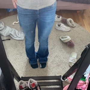 Blå bootcut jeans med normal midja - Säljer ett par klassiska blå jeans med bootcut-modell och normal midja. Jeansen har fem fickor, dragkedja och knapp framtill. Snygg tvätt med lätt slitning och sköna att bära till vardags. Perfekta om du gillar en tidlös jeansstil. Materialet är mjukt denim så de är stretchiga och det är mid waist! De är lite långa på mig så skulle säga att de passar någon runt 165+ lite bättre ;)