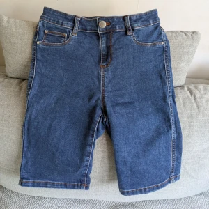 Jeansshorts från Jane Shorts - Mörkblåa jeansshorts i tight modell från Jane Shorts. Jag är ca 170 cm för referens. Vid köp av flera klädesplagg av mig samfraktar jag såklart!