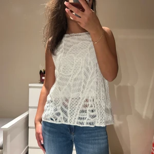 Vit stickad ärmlös linnetopp - Säljer en vit stickad linnetopp med underlinne från Primark. Helt ny, aldrig använd. 