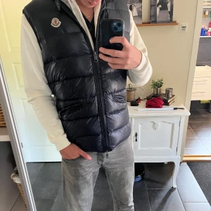 Blå gui väst från moncler  - Säljer en blå, glansig dunväst från Moncler. Västen är i storlek 4 som motsvarar L men sitter som M, bara att skriva ifall ni har några funderingar (priset är ej hugget i sten 
