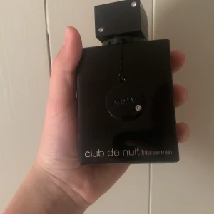 Club de Nuit Intense Man parfym - Säljer en Club de Nuit Intense Man parfym från Armaf. Flaskan är helsvart med en fyrkantig form och har dekorativa stenar på korken och en svart medaljong hängande framtill. En klassisk och populär herrdoft i snygg design. Har endast sprayat ett spray med den. 
