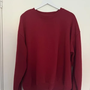 Mörkröd crewneck sweatshirt - Enkel och stilren mörkröd crewneck sweatshirt med rund halsringning och långa ärmar. Tröjan har en oversized passform och är tillverkad i mjuk bomull, perfekt för en chill och avslappnad look.