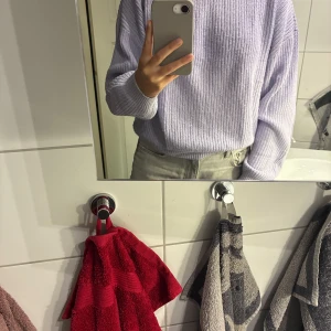 Ljuslila stickad tröja med ribbad struktur - Supermysig ljuslila stickad tröja med ribbad struktur och rund hals. Avslappnad passform och långa ärmar, perfekt för lager på lager under vintern. Enkel att matcha med både jeans och kjol för en chill look.