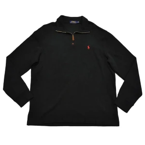 NY Ralph lauren quarter zip - Svart långärmad tröja från Polo Ralph Lauren med klassisk röd logga på bröstet. Tröjan har en snygg half zip-dragkedja med läderdetalj och stårkrage. Tillverkad i mjuk bomull, perfekt för lager-på-lager under höst och vinter.