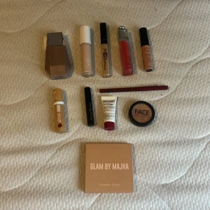 Sminkpaket med foundation, concealer, läpprodukter och rouge - Stort sminkpaket med Fenty Beauty foundation, e.l.f. primer, Maybelline Fit Me concealer, Dior läppglans, NYX läppkräm och läppenna, Zao läppstift, Face Stockholm rouge, Glam by Majha powder blush, svart mascara och Biotherm läppbalsam.