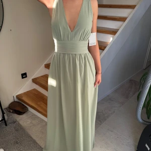 Ljusgrön långklänning med djup v-ringning - Säljer en superfin ljusgrön långklänning med djup v-ringning och bred markerad midja. Klänningen är ärmlös och passar perfekt som en balklänning. Storlek är 36 men passar även mig som har 34. Klänningen är helt oanvänd. Pris kan alltid diskuteras💞