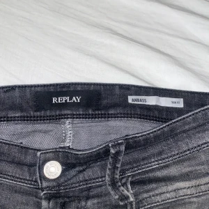 Replay Anbass svarta jeans - Säljer ett par Replay Anbass jeans i svart tvätt med slim fit. Jeansen har klassisk femficksdesign, dragkedja och Replay-logga på fickan. Snygg slitning och detaljer som ger en cool look.