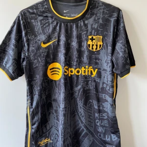 Barcelona fotbollströja - Snygg och stilren svart matchtröja från FC Barcelona. Officiell design med klubbmärke och Nike-logga på bröstet. Tröjan är i storlek Small och sitter perfekt för dig som gillar en slim fit-passform. Perfekt både på läktaren och till vardags. Bra skick, inga hål eller fläckar. Ett måste för varje Barça-supporter!