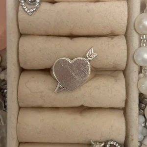 Silverring med hjärta och pil - Säljer en snygg silverring med ett hjärta som har en pil genom sig från l8 hasselblad. Köpt för 1100kr.