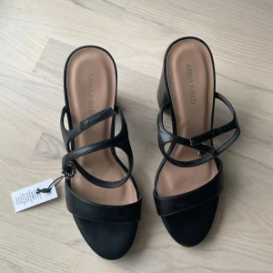 Svarta klackskor från Anna Field - Säljer ett par stilrena svarta klackskor från Anna Field storlek 39. Skorna har öppen tå och en elegant design som passar perfekt till många olika outfits. Skorna är oanvända. Upphämtning sker i Täby eller Ulriksdal. 
