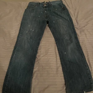 Levis 501 blå jeansbyxor - Klassiska blå Levis 501 jeans med raka ben och normal passform. Byxorna har fem fickor, knappgylf och Levis ikoniska läderpatch bak. Perfekta för en avslappnad stil och funkar året runt.