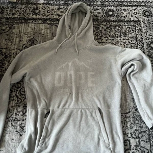 Dope hoodie - grå - Dope hoodie med mjukt matrial. Den är knappt använd så inga skavanker på plagget. Storleken är bra & rättvis