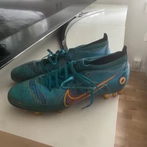 Blå Nike fotbollsskor med orange detaljer - Säljer ett par blå  Nike mercurial vapor 14 (AG dobbar)! Använda en säsong pris går att diskuteras! 
