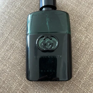 Gucci Guilty Black Pour Homme EdT - Gucci Guilty Black Pour Homme är en herrparfym med en stilren svart och mörkgrön flaska. Flaskan har Guccis ikoniska logga framtill och är tillverkad i glas med en blank finish. Doften är maskulin och modern.