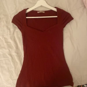 Vinröd ribbad topp från Anna Field - Säljer en vinröd ribbad topp från Anna Field med korta ärmar och snygg v-ringning. Skriv för fler frågor storleken är xs/s men stretchigt material