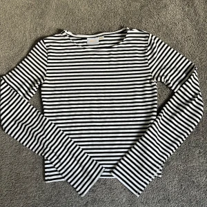 Svartvit randig långärmad tröja från Gina Tricot - Säljer en klassisk svartvit randig långärmad tröja från Gina Tricot. Tröjan har rund halsringning och är i ett mjukt bomullsmaterial. Perfekt för en enkel och stilren look.