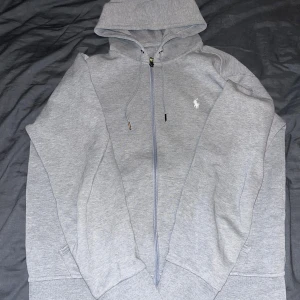 Grå zip hoodie från Ralph Lauren - Säljer en grå zip hoodie från Ralph Lauren. Den är i bra skick och i storlek M. Säljer då den blivit för liten men den har bra passform. Hör av er vid funderingar.