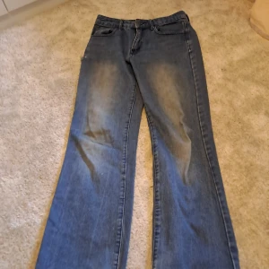 Blå jeans från Shein Jeans med slitningar - Säljer ett par blå jeans från Shein Jeans med raka ben och slitna detaljer vid fickor och benslut. Klassisk femficksmodell med knapp och dragkedja framtill. Perfekta för en avslappnad och trendig look🩶