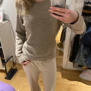 Beige stickad tröja - Mysig beige stickad tröja med rund halsringning och långa ärmar. Tröjan har en enkel och klassisk design med ribbade muddar vid ärmslut och nederkant. Perfekt för lager-på-lager under kyligare dagar. Väl använd eller lite väl hårt tvättad så nipprig, kom privat för exakta bilder på det☺️🥰