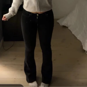 Svarta low flare jeans - Säljer ett par svarta jeans med låg midja och utsvängda ben från bikbok💞 Modellen är low flare och byxorna har klassisk femficksdesign med knapp och dragkedja framtill. Inga defekter, säljer då de sitter lite för tight.