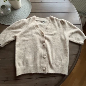 Beige stickad kofta med knappar från zalando - (Meddela innan köp) Mysig beige stickad kofta med v-ringning och stora matchande knappar på framsidan, tröjan är bara använd typ 2-3 gånger❤️Den är i väldigt bra skick och inga hål eller fläckar. Koftan är i en liten storlek men den är större än vad man tror