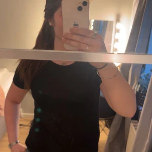 Svart glittrig topp - Säljer en svart glittrig topp med korta ärmar . Enkel och stilren design som passar till många tillfällen. Storlek M men passar S