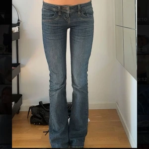Blå bootcut jeans från LTB - Säljer ett par klassiska blå bootcut jeans från LTB med låg midja. Jeansen har fem fickor, snygga kontrastsömmar och en figurnära passform upptill som går ut i ett bootcut nertill. Perfekta till sneakers eller boots.