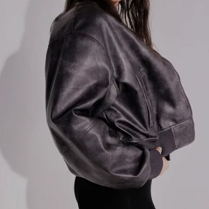 Oversized svart skinnjacka - Säljer en oversized svart skinnjacka med breda axlar och ribbade muddar. Jackan har en cool, boxig passform och dragkedja framtill. Prislapp kvar och aldrig använd