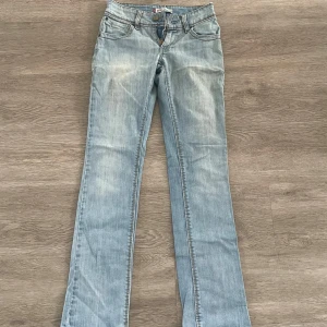 Ljusblå Levis Jeans - Säljer ett par skitsnygga lågmidjade Levis jeans i bra skick!🤩Säljer då de tyvärr är för små för mig :/ Dragkedjan har hoppat ur på ena sidan men det går att lämna in och fixa! Står ingen storlek men skulle gissa 24-25 i midjan❤️ Midja tvärsöver: 32 cm      Innerbenslängd: 77 cm